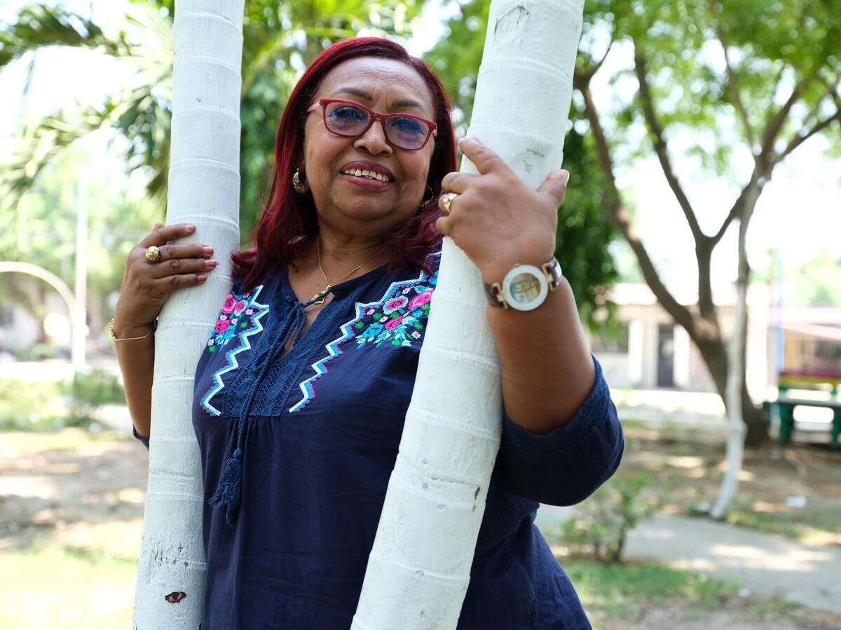 Susana, 65 ans, sourit dans le parc rénové de sa communauté. 