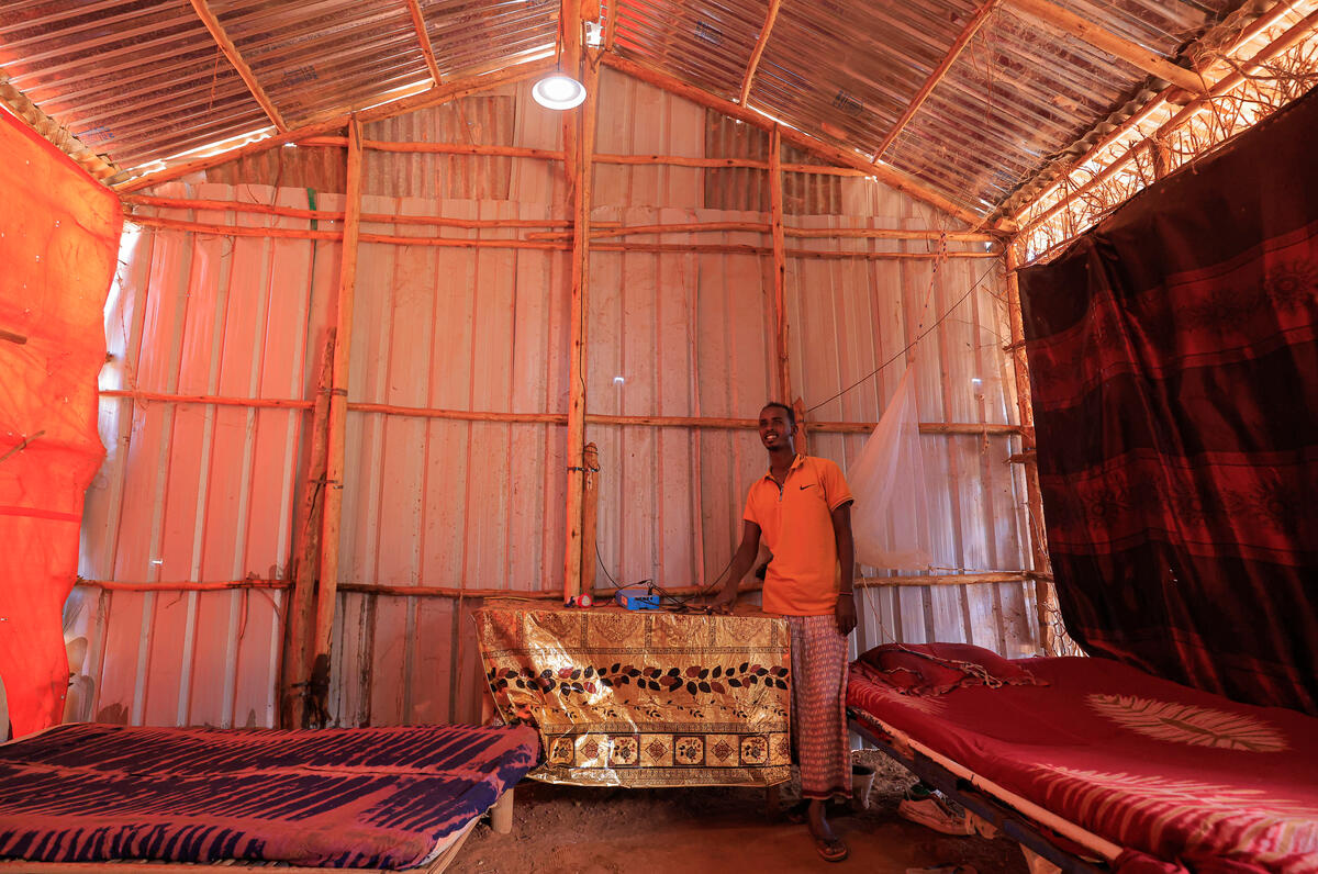 Un homme allume une lumière à l'intérieur de sa maison