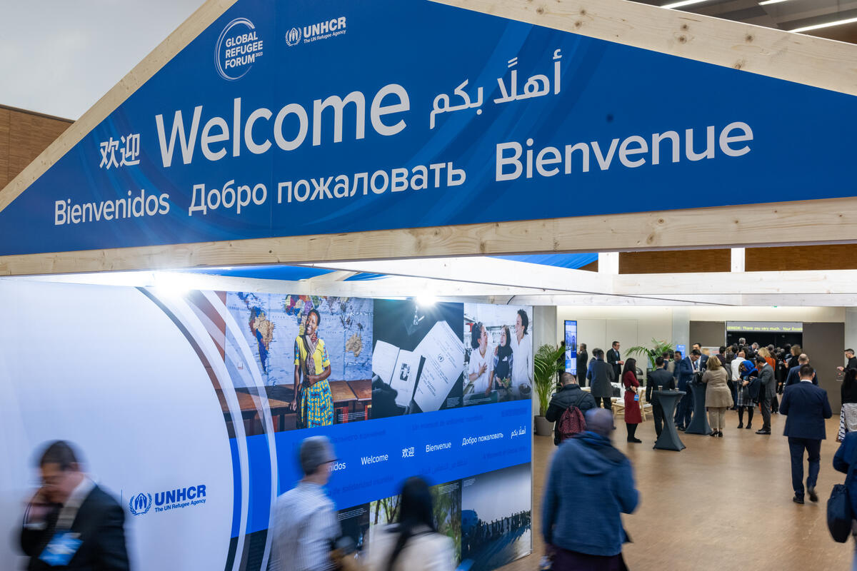Un panneau de bienvenue, avec le mot "Bienvenue" en plusieurs langues, au-dessus de l'entrée du Forum mondial sur les réfugiés 2023.