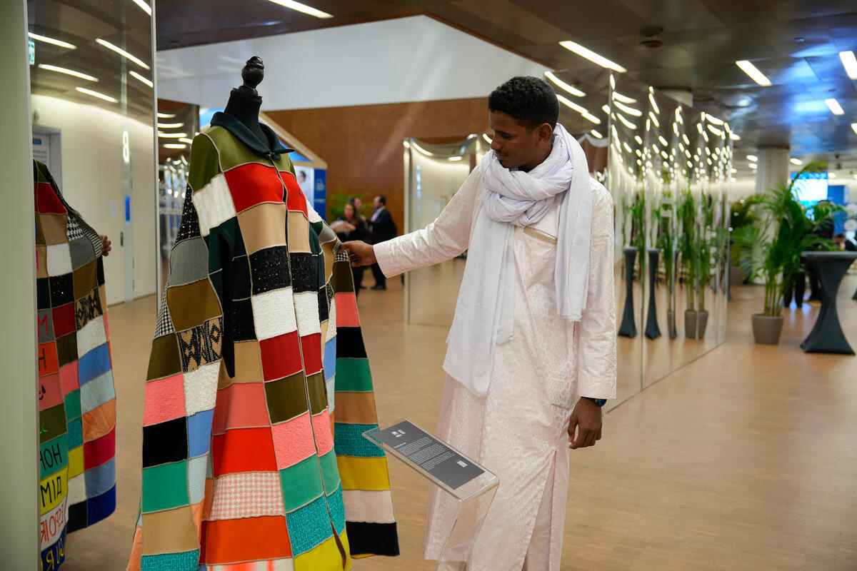 Mohamedoun Ag Agalileye regarde une cape portée par Miyavi, ambassadeur de bonne volonté du HCR, dans le cadre de la campagne L'espoir loin de chez soi