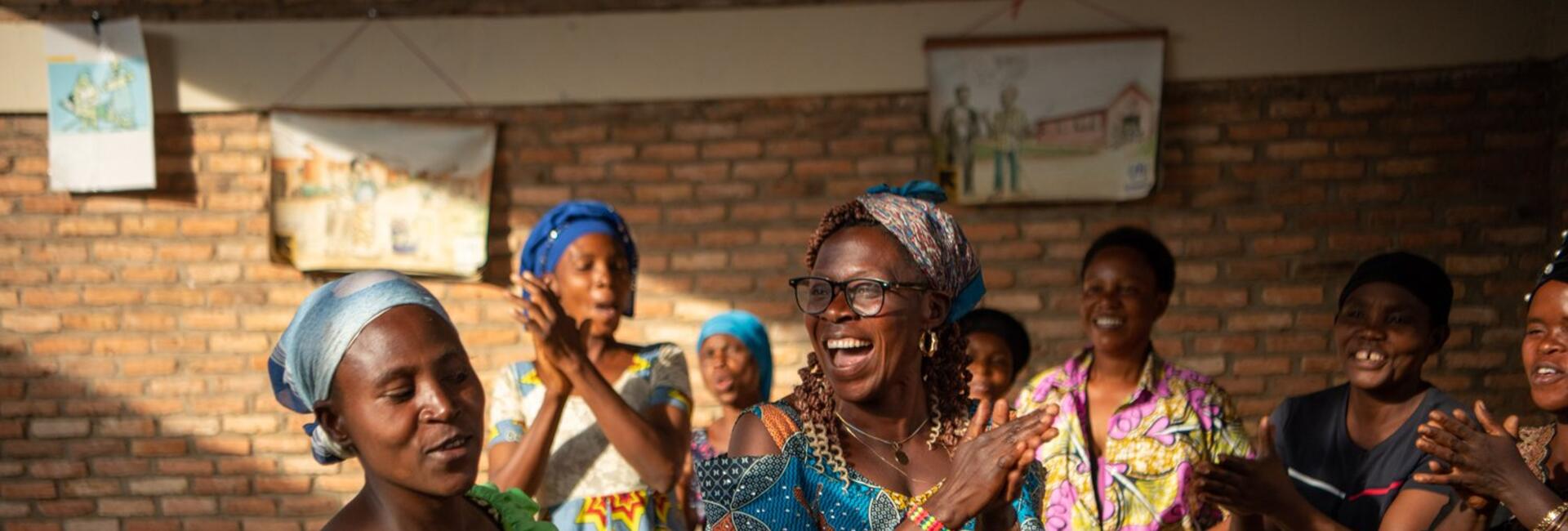 Women clap and dance together.