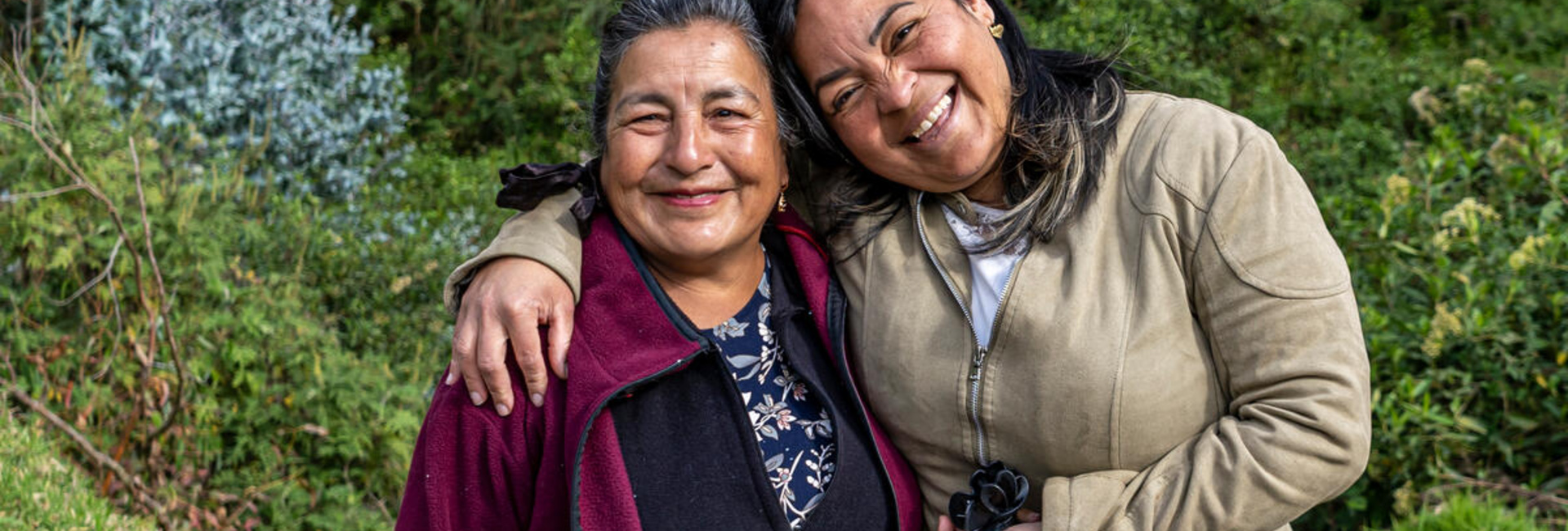 Une Equatorienne de 67 ans et une Vénézuélienne de 39 ans s'embrassent et célèbrent leur amitié au bord d'une rivière.