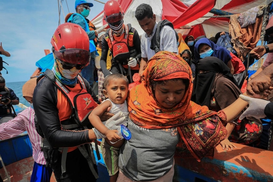 Des membres du personnel du HCR aident des réfugiés rohingyas à débarquer dans le sud de l'Aceh, en Indonésie, en octobre 2024, après des semaines en mer. 
