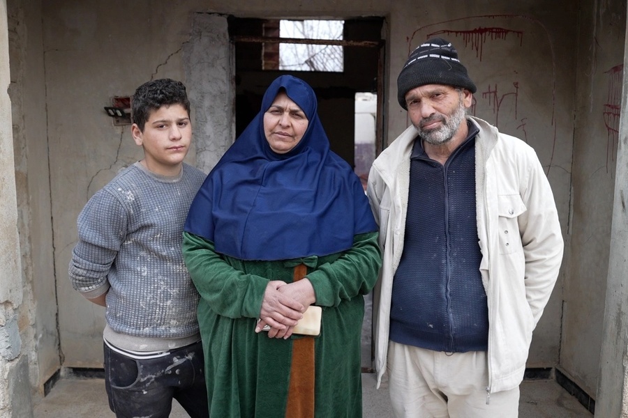 Ibtihal (au centre), Abu Abbas (à droite) et Omar (à gauche), anciens réfugiés, devant leur maison endommagée par les bombardements dans le gouvernorat de Deraa, dans le sud de la Syrie.