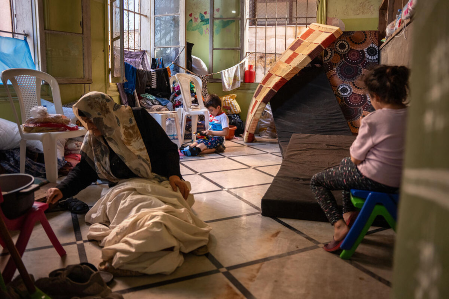 Une femme âgée et deux jeunes enfants dans une salle de classe