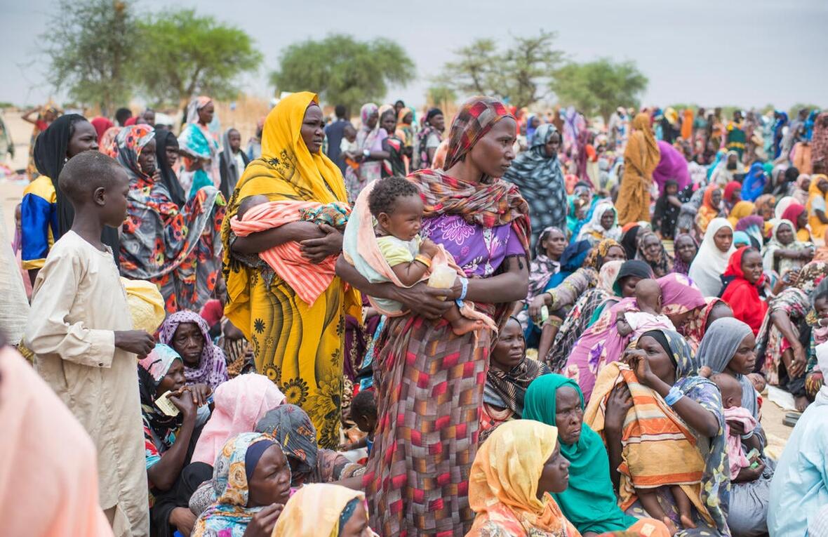 Des femmes soudanaises réfugiées et des enfants rassemblés pour recevoir des kits d'aide du HCR.