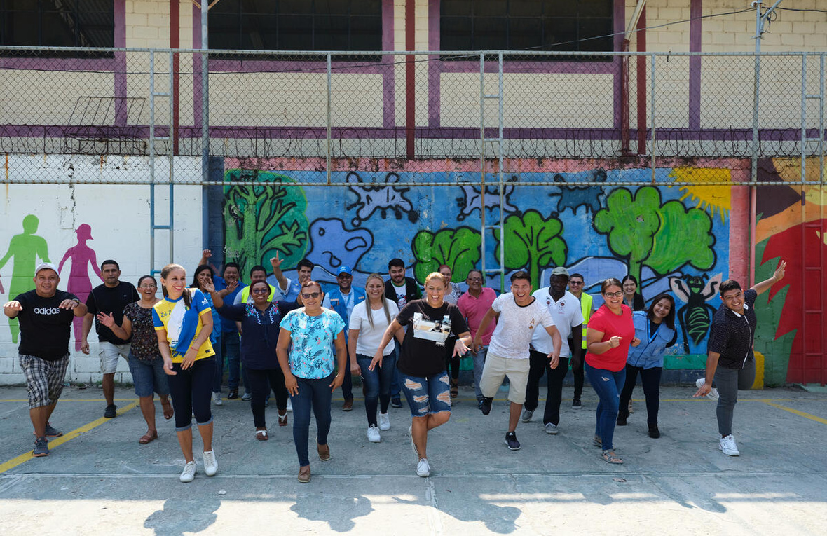Des volontaires de la communauté de Chamelecón se sont réunis devant une peinture murale.