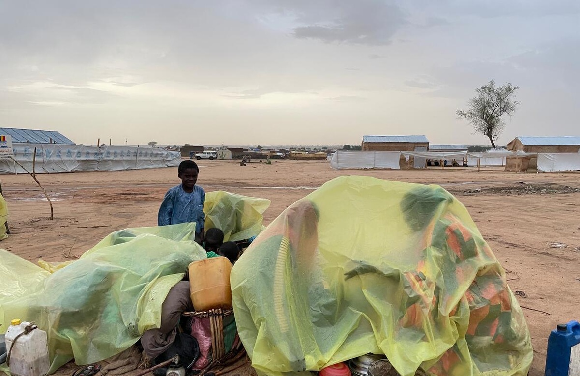 Les gens utilisent des bâches en plastique pour s'abriter de la pluie.
