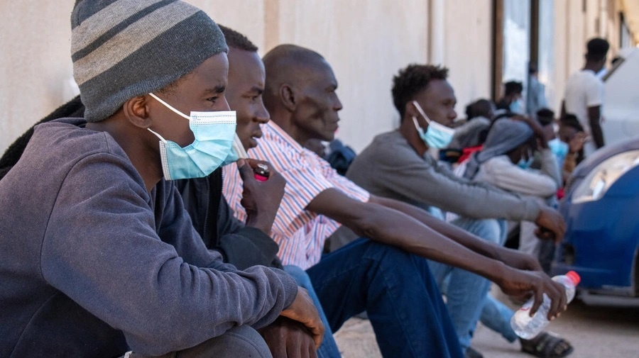   Des réfugiés et des demandeurs d'asile libérés du centre de détention d'Ain Zara à Tripoli, la capitale libyenne, attendent à l'extérieur d'un bâtiment des Nations Unies pour bénéficier d'une aide financière et alimentaire en mai 2022. 