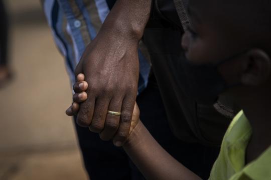 Child holding hand with man