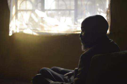 Old person sitting near window