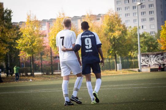 Two football players side by side in a football field