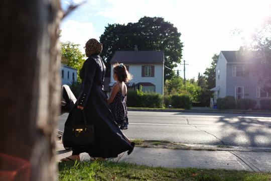 Mother and child walking on sidewalk