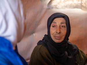 在敍利亞西北部鄉郊的非正式營地中，55歲的Sana Khaled與一名聯合國難民署的工作人員正在她的家庭帳篷裡交談。