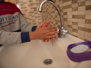 Jordan. Qusai (11) washes his hands in the sink at home