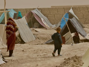 A woman and child walk between the makeshift tents in Nawabad Farabi-ha camp for internally displaced people in Mazar-e Sharif in northern Afghanistan.