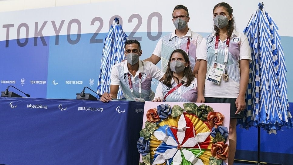 Members of the Refugee Paralympic Team stand with more than 3,000 paper airplanes during a press conference ahead of the Tokyo 2020 Paralympic Games. © OIS/Joe Toth