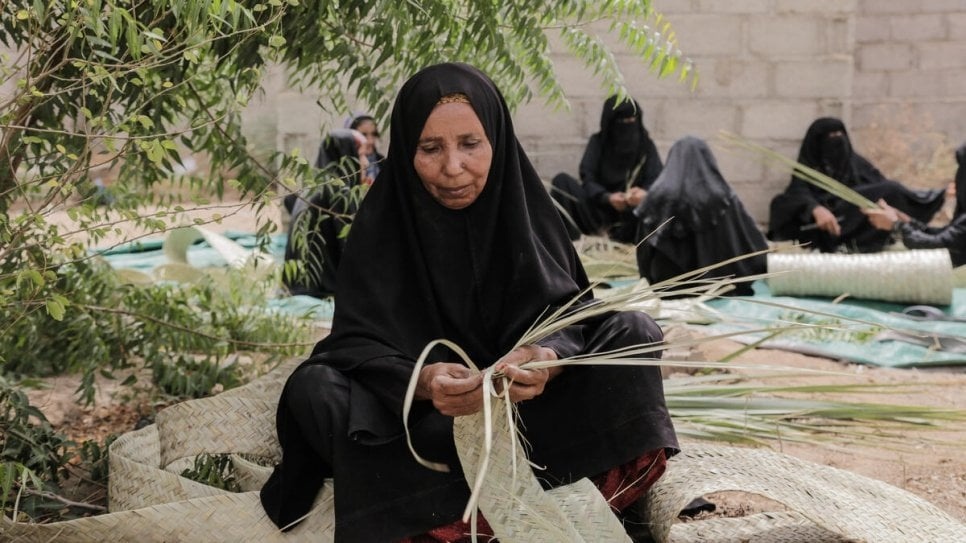 Yemeni women at a displacement site near Hudaydah weave khazaf palm fronds used in the construction of environmentally sustainable shelters. © UNHCR/Abdulhakeem Obadi