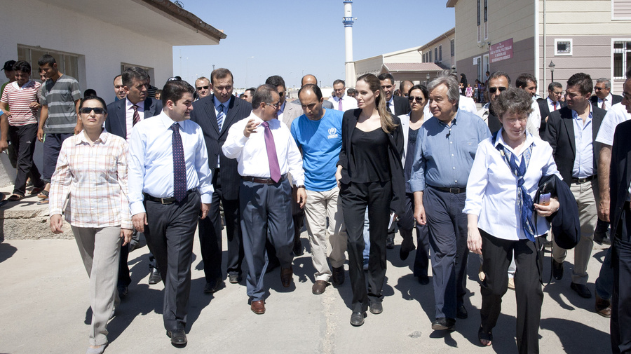 Angelina Jolie (in black) and António Guterres (next to her in blue open neck shirt) tour a camp housing thousands of Syrian refugees in Turkey.