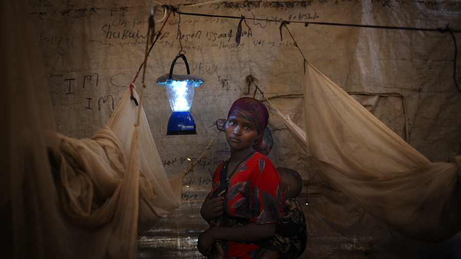 A solar-powered lantern helps this Somali mother and her child in their shelter eastern Ethiopia's Kobe Refugee Camp
