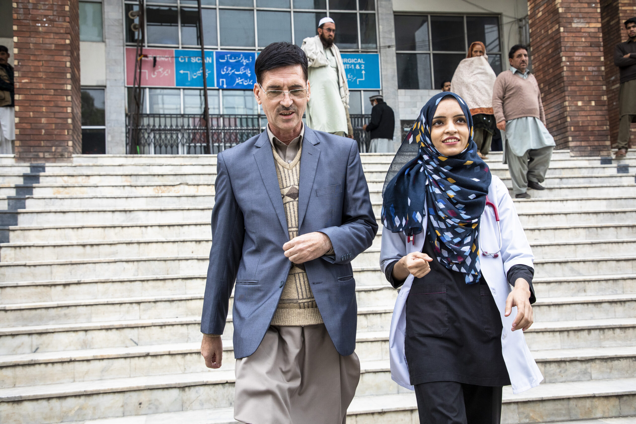 Saleema及她49歲的父親Abdul Rehman步出聖家醫院，Abdul表示：「如果我的社群中有人因為我有個醫生女兒而找我提出問題，我會為我們感到驕傲。」 © UNHCR/Roger Arnold