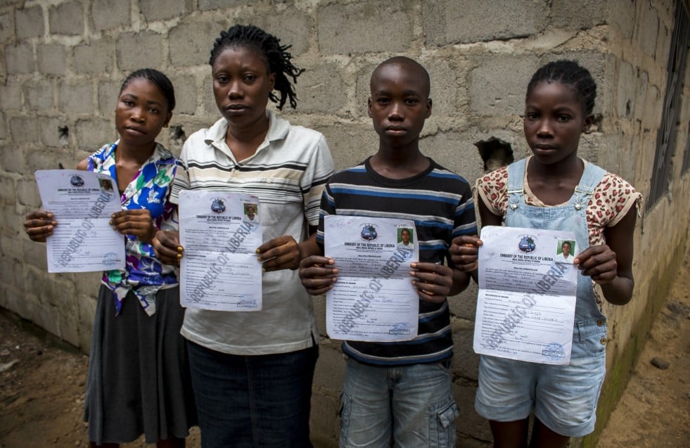 Georgia and her children, who are stateless, hold up the only identification document they possess.