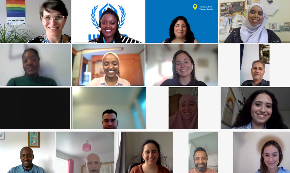 A group of 16 people on a zoom call smile to the camera.