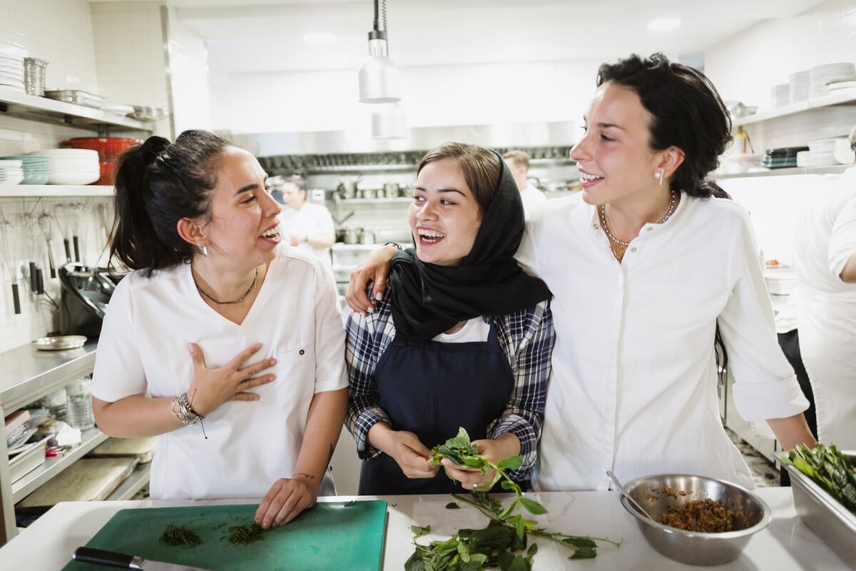 Roya Saifi (centre), an Afghan refugee, cooks with chefs Eleni Saradi (right) and Ilectra Rigkou (left) in the Lost Athens restaurant, Greece.