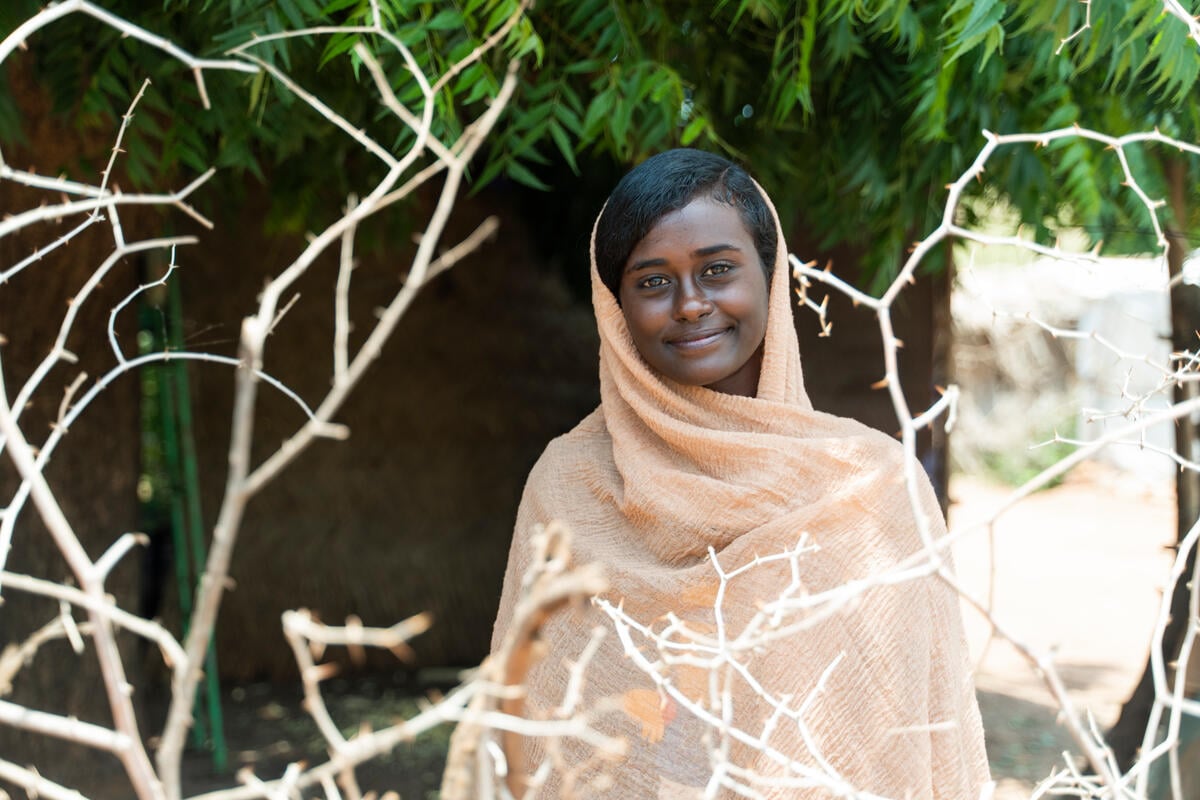 A smiling Sudanese woman, outside