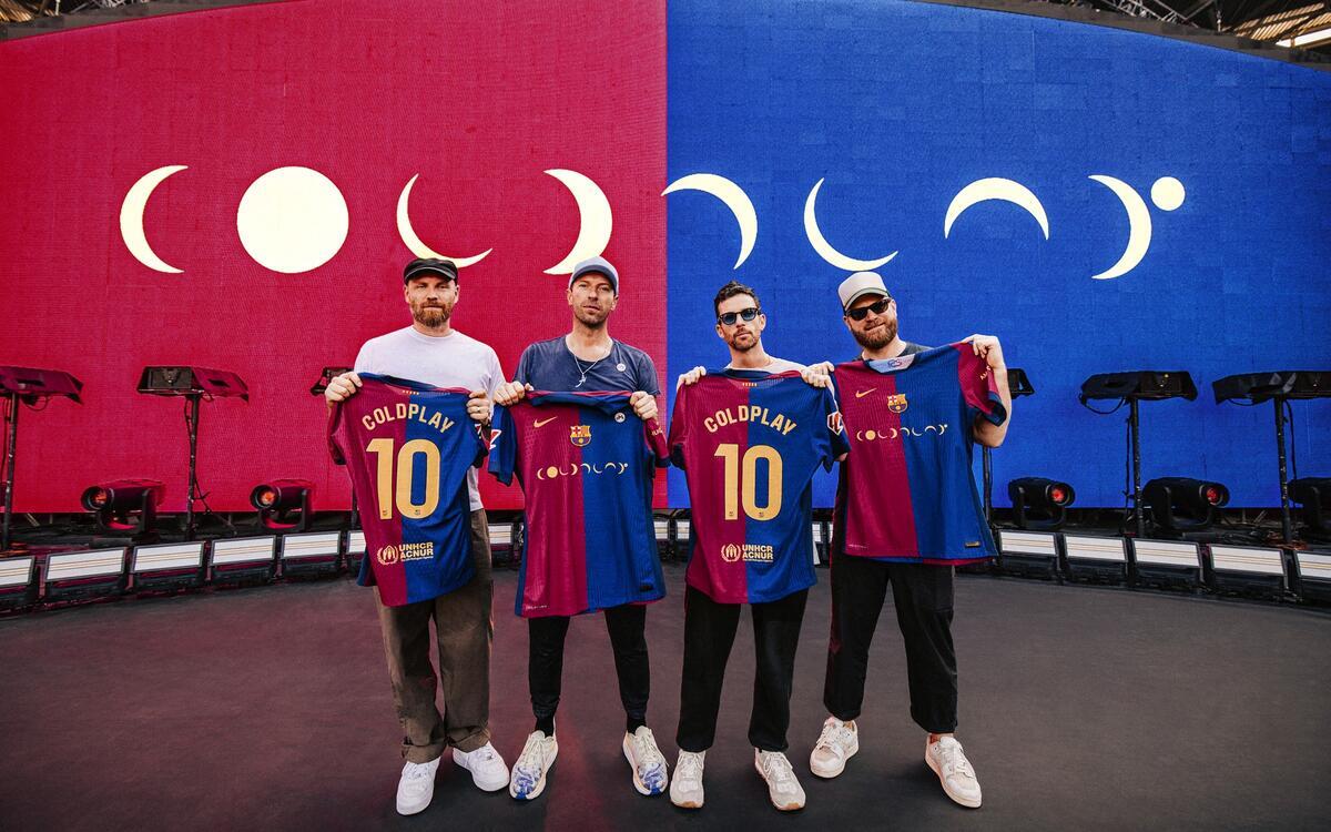 The four men from Coldplay pictured holding the FC Barcelona jersey, which says Coldplay and 10 on it.