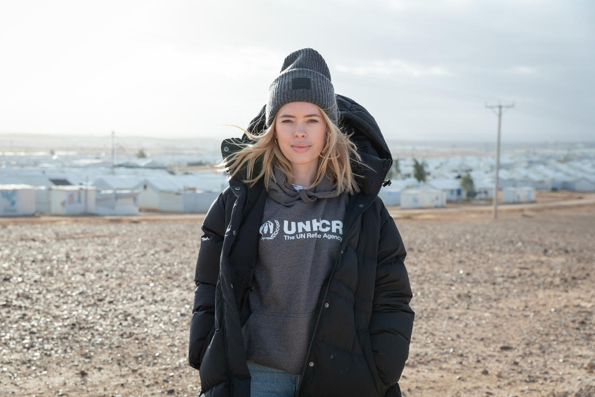 Tanya Burr standing on a high point overlooking a refugee camp.