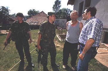 K-FOR and UNHCR staff check on Kosovo Serbs surrounded by ethnic Albanians.