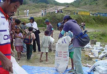 East Timorese refugees receive supplies as they return through the Lakhmaras ridge in East Timor.