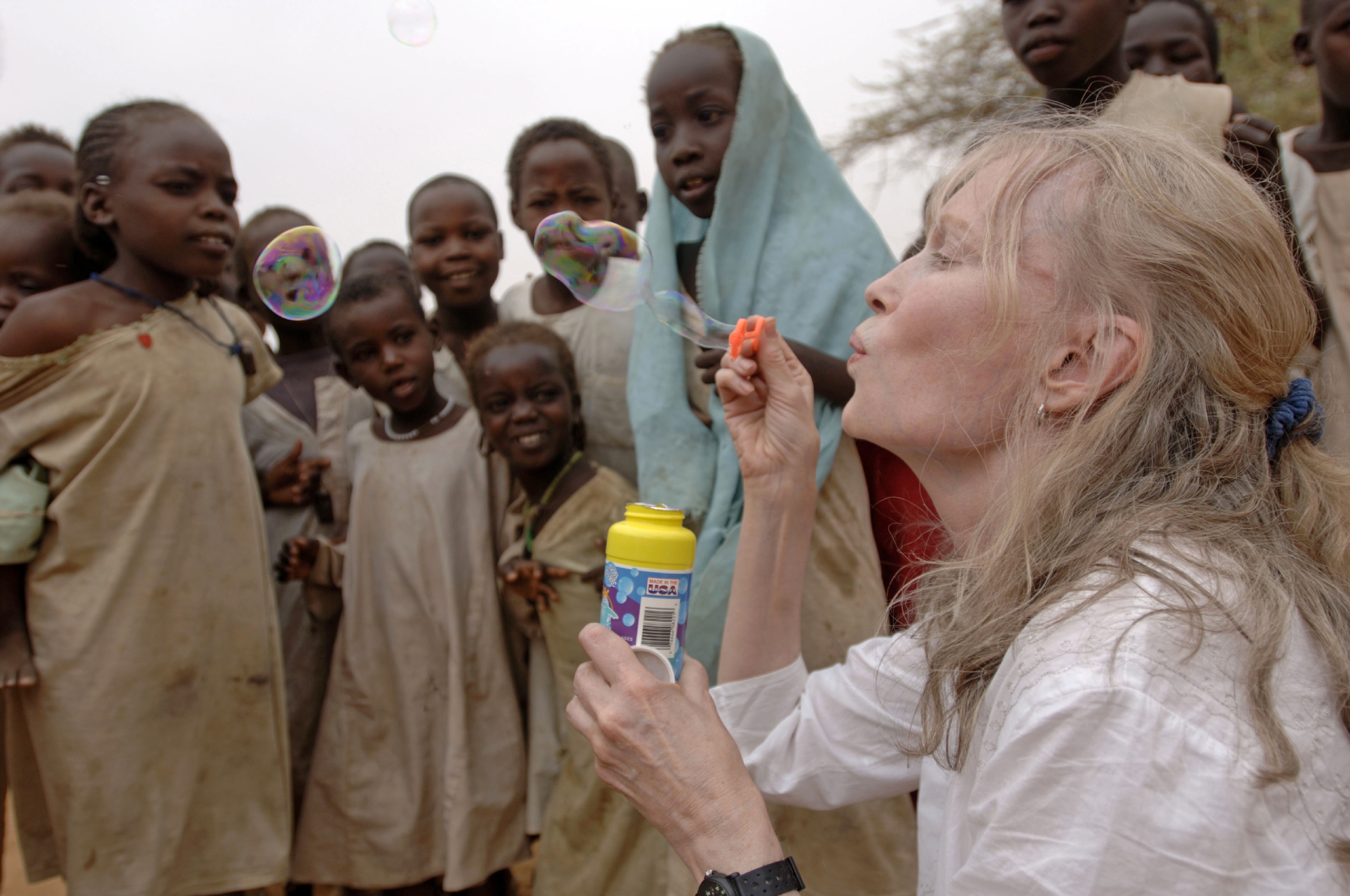 Actress and UNICEF Goodwill Ambassador Mia Farrow blows soap bubbles to the delight of children at the Zam Zam camp for people displaced by the conflict in Darfur.