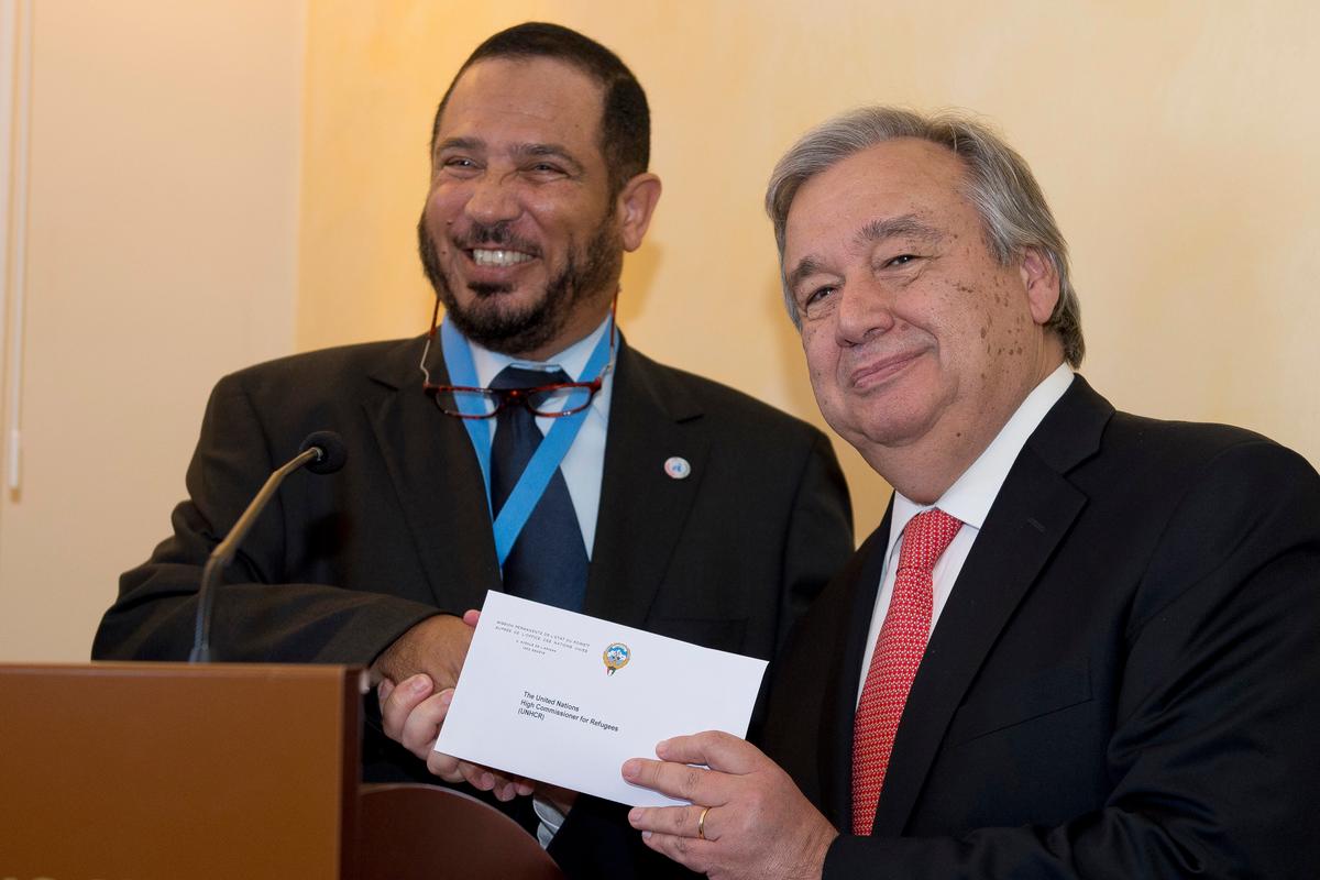 António Guterres, the UN High Commissioner for Refugees, holds the cheque he has just received from Abdullah Al-Matouq, advisor to the Emir of Kuwait.