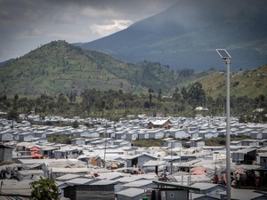 A displacement site surrounded by mountains on a cloudy day.