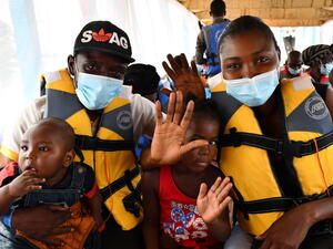 Central African returnees wave as the boat carrying them back to their homeland leaves Zongo in the Democratic Republic of the Congo, November 2020.