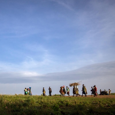 A group of people walks in a field.