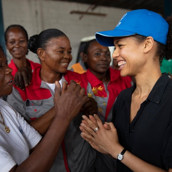 Gugu Mbatha-Raw laughs with refugee women.