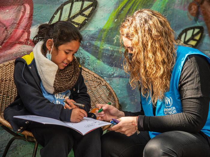 Girl who after being vaccinated paints a coloring book created by the Red Cross International and UNHCR specially for refugee and migrant children who arrive to the country.
