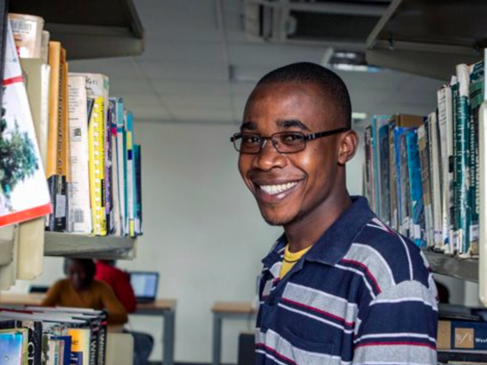 A man smiles, a book in his hands