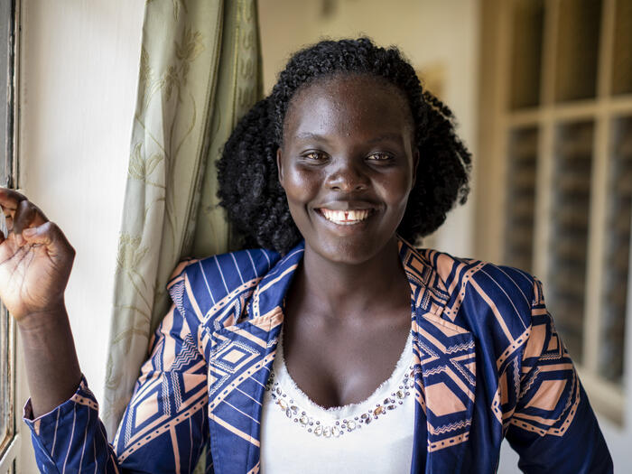 UNHCR, the UN Refugee Agency - Esther smiles into the camera. She is a third-year student in commerce at Makerere University in Kampala. 