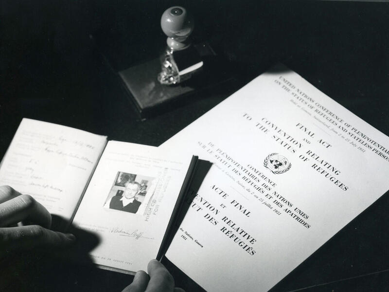 A black and white photo showing travel documents and The Convention Relating to the Status of Refugees.