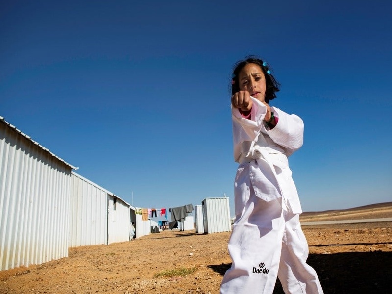 A young girl practices karate moves.