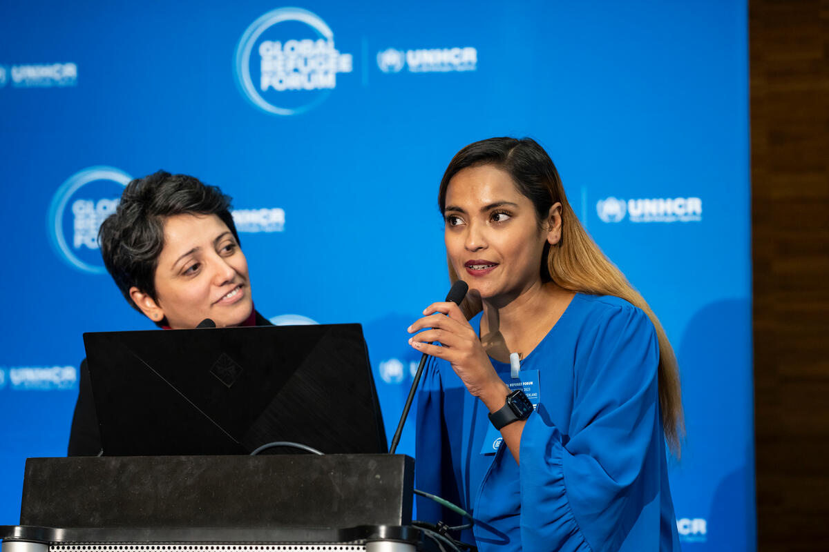 Two women at a lectern with a GRF banner behind them