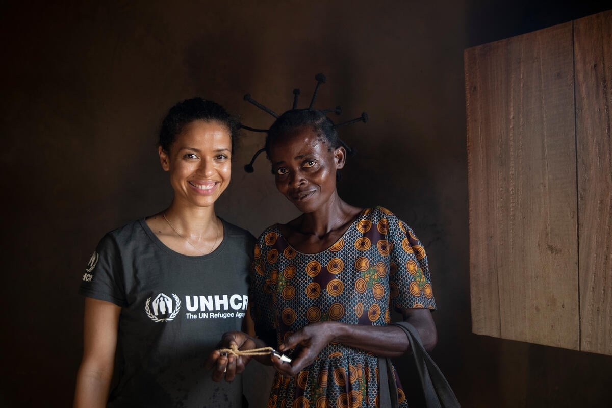 Gugu Mbatha-Raw stands next to refugee woman Veronique Bundu in her new home.