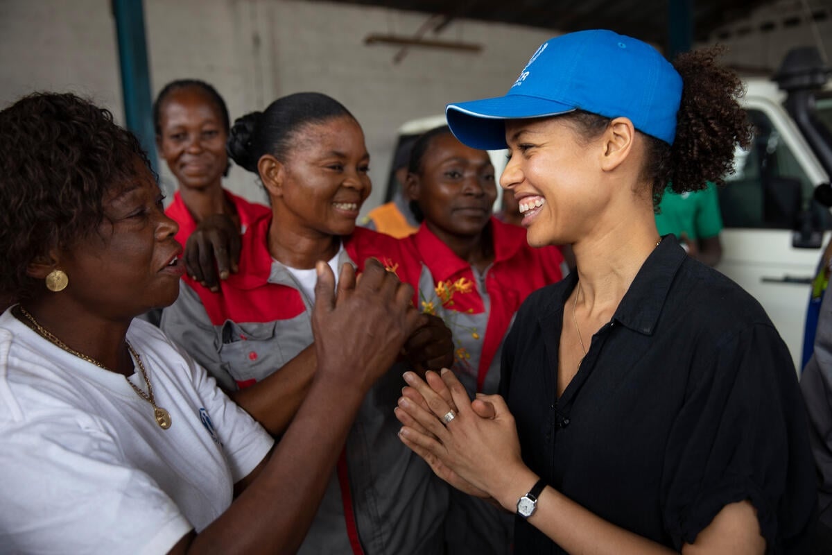 Gugu Mbatha-Raw laughs with refugee women.