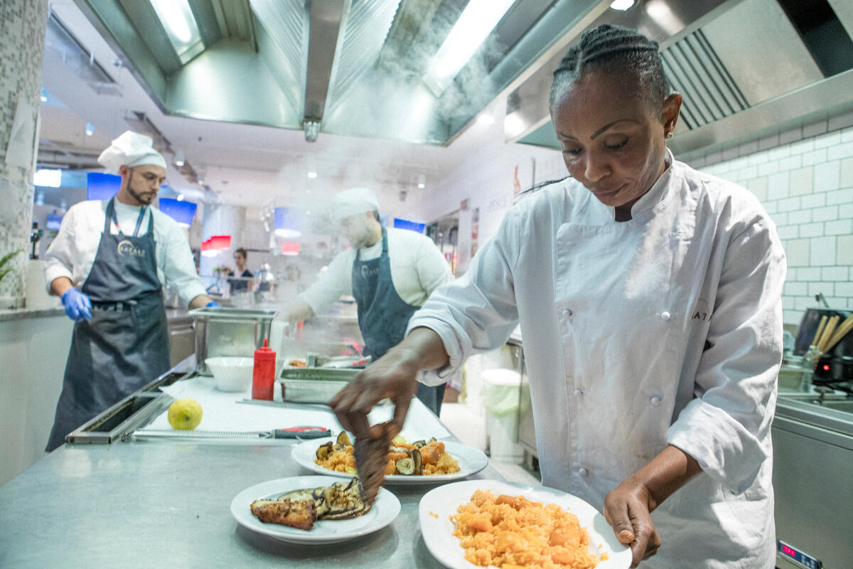 Italy. Refugee from DRC prepares fish dish