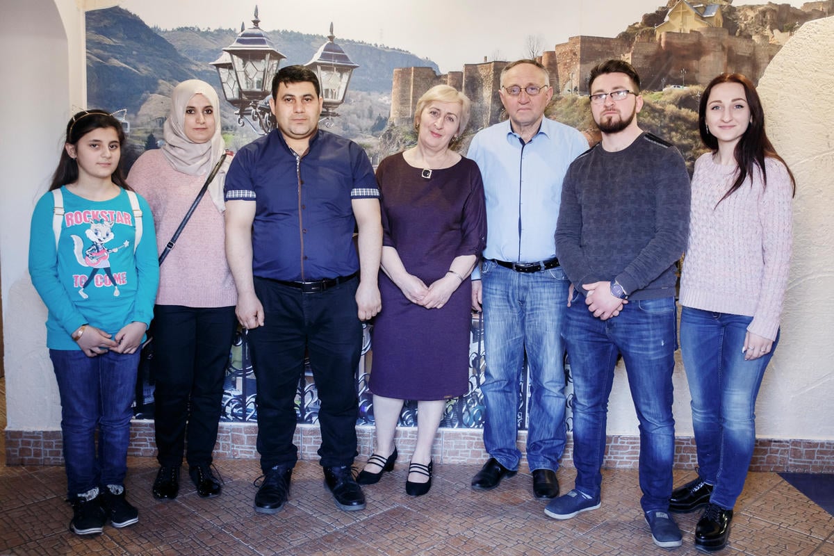 Belarus. A group photograph of future business partners - a Syrian refugee family and a family of former Georgian refugees