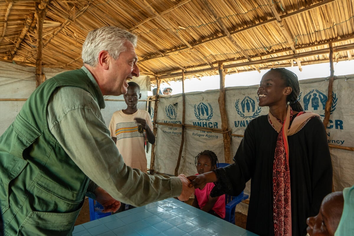 Filippo Grandi shakes hands with Dalia, both smiling.